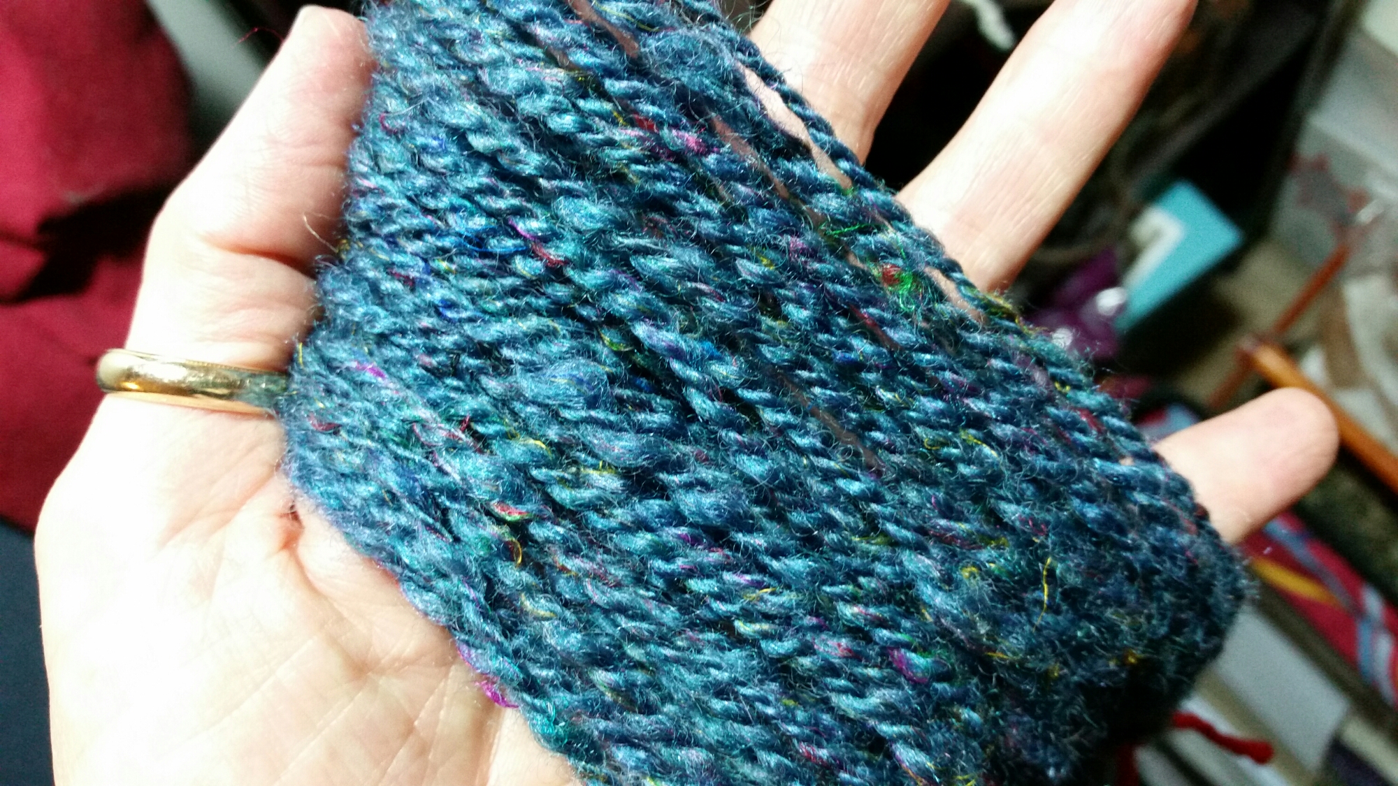 Yarn spun from hand-carded SGY Riptide and Nightshade BFL-Silk Blend, with sari silk fibers included.
